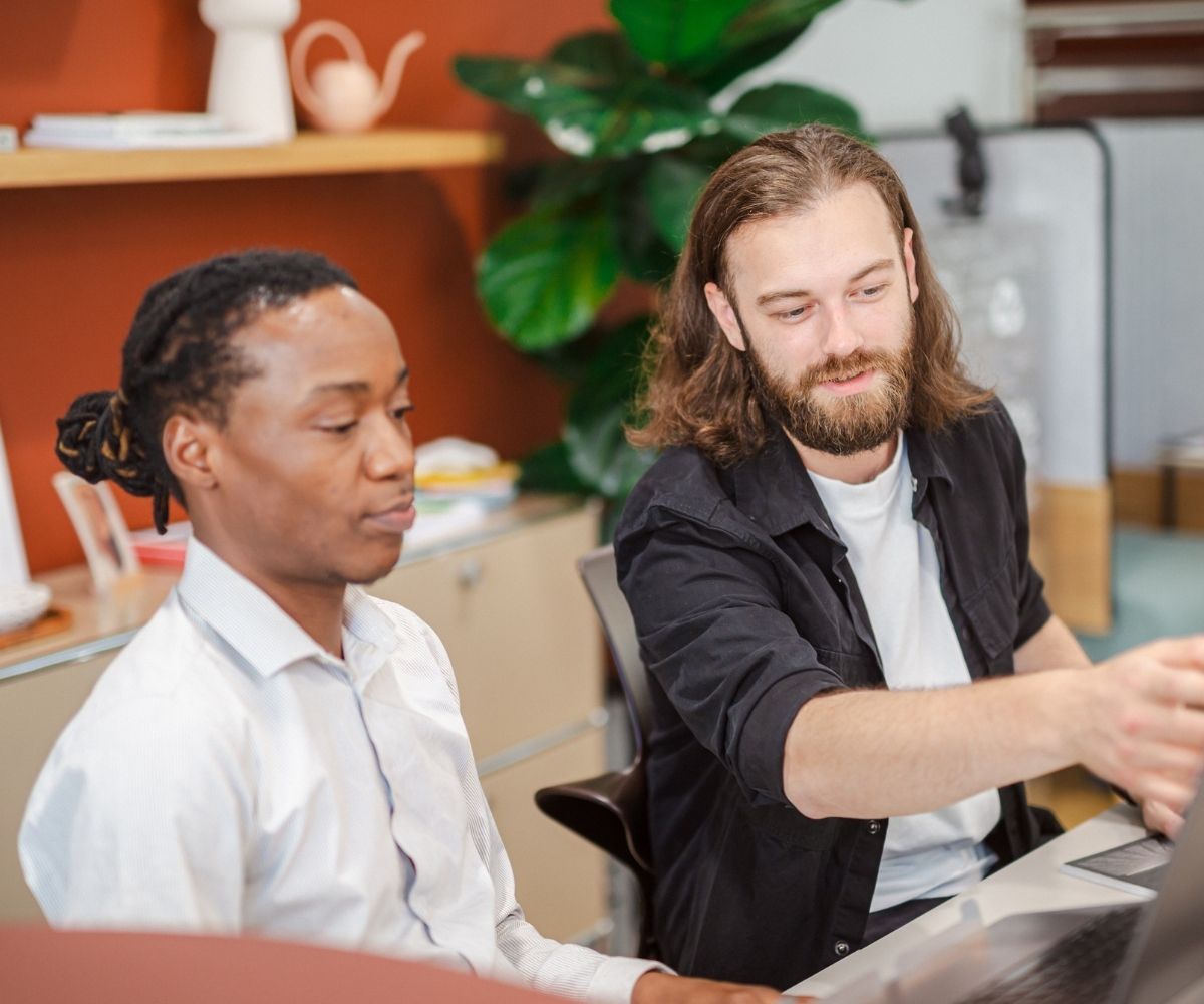 Assistive Technology Training session with two colleagues collaborating at a desk using a laptop