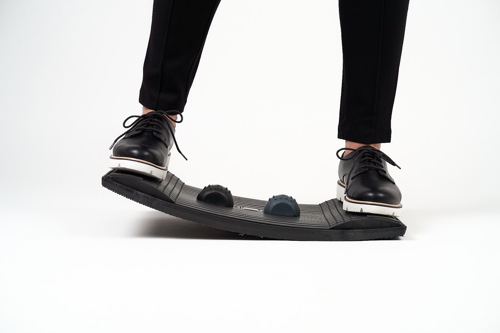 Gymba balance board in use, front view showing ergonomic balance board with active standing foot placement for workplace movement.