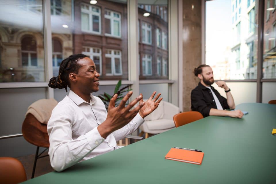 Strategy meeting taking place in a modern office, showing colleagues engaged in discussion around a conference table to support planning, collaboration, and decision making.