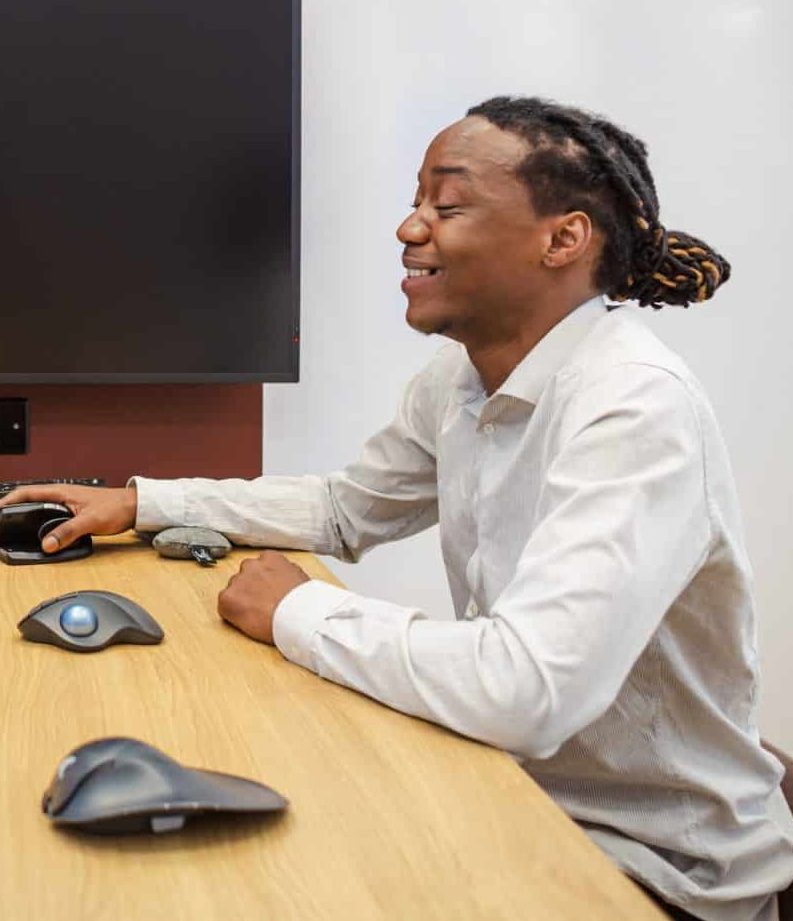 DSE assessment showing an employee trialling different ergonomic computer mice during a workstation evaluation to improve comfort and reduce strain.
