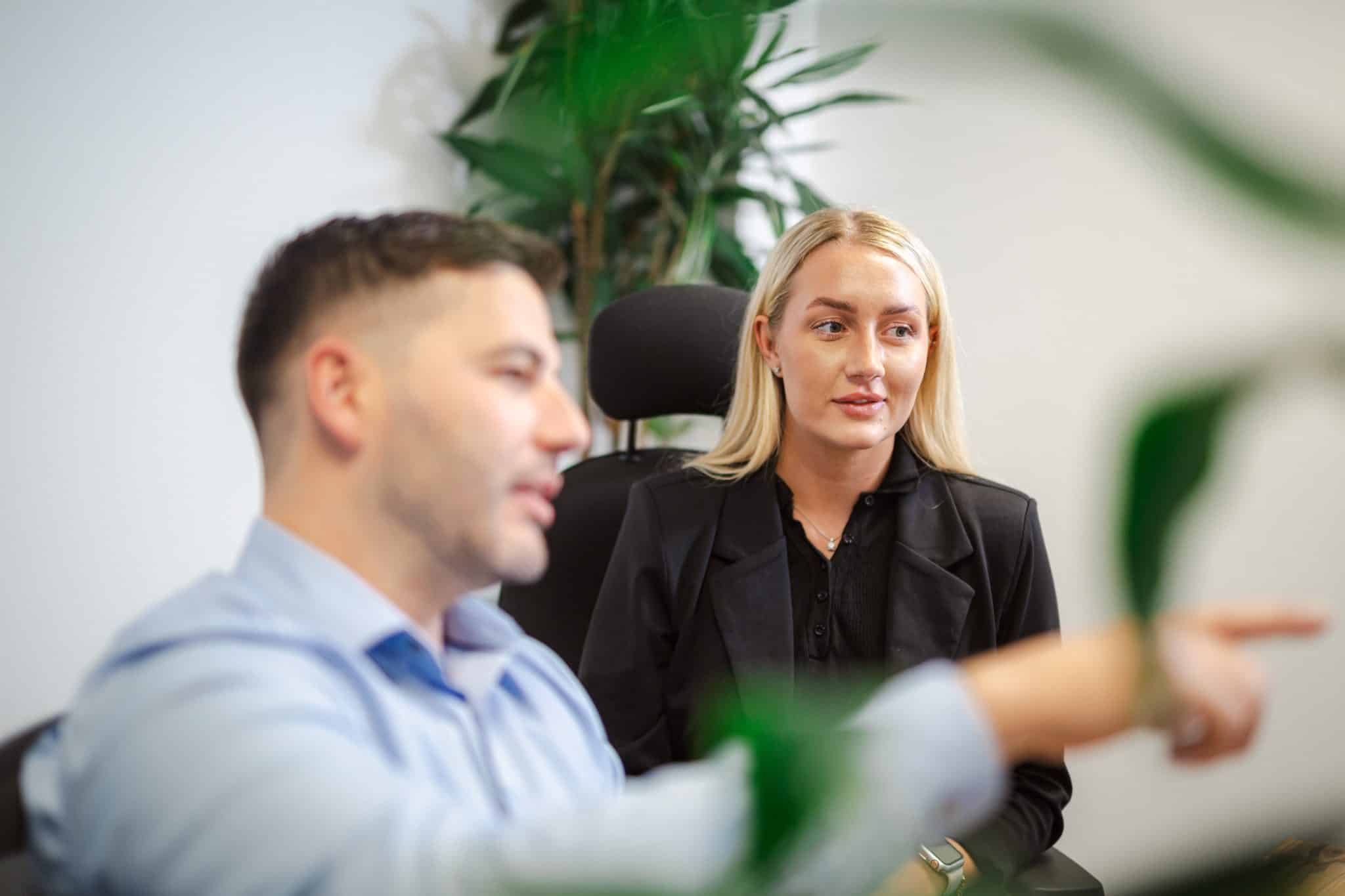 Workplace leadership image showing a leader and colleague in discussion, demonstrating guidance, decision making, and collaborative leadership in a professional setting.