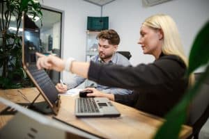 Remtek promotional image showing a workplace consultation in progress, with team members reviewing a laptop based workstation and discussing ergonomic adjustments.