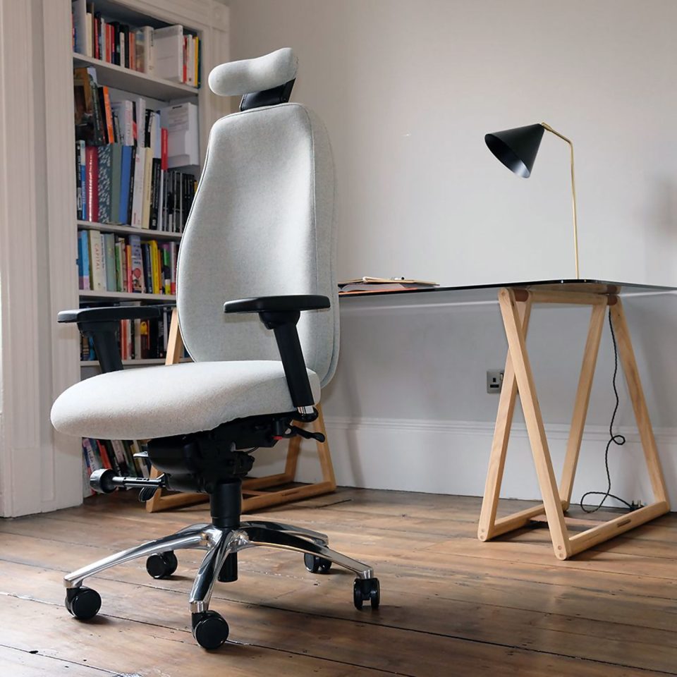 Ergochair Adapt 610 ergonomic chair, upholstered in light grey. image shows chair in a home setting, infront of a desk and white bookcase