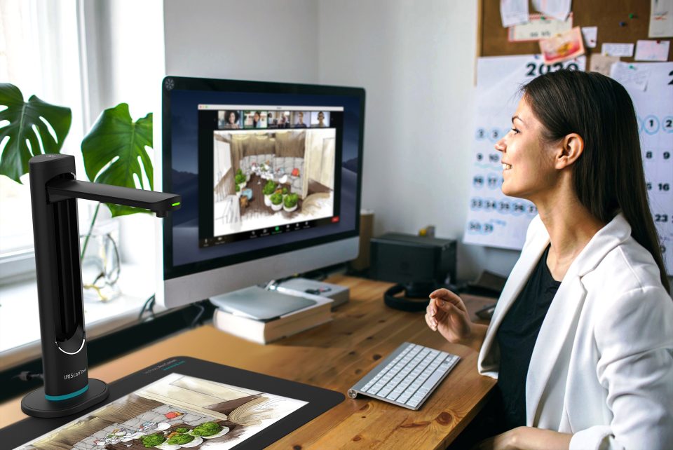 IRIScan Desk 6 Business in use with a document scanned to a screen. a woman in a white jacket is viewing the screen