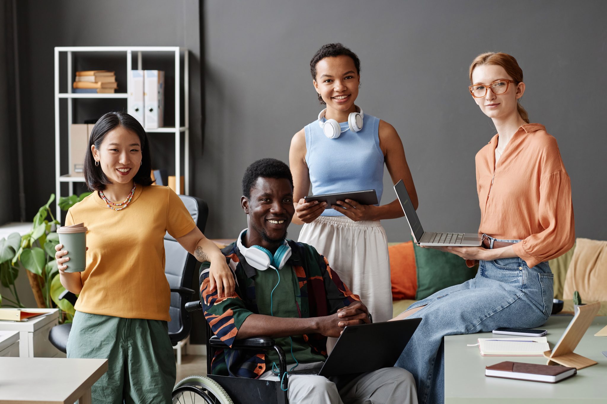 Front view portrait of inclusive diverse business team smiling at camera while posing together in modern office