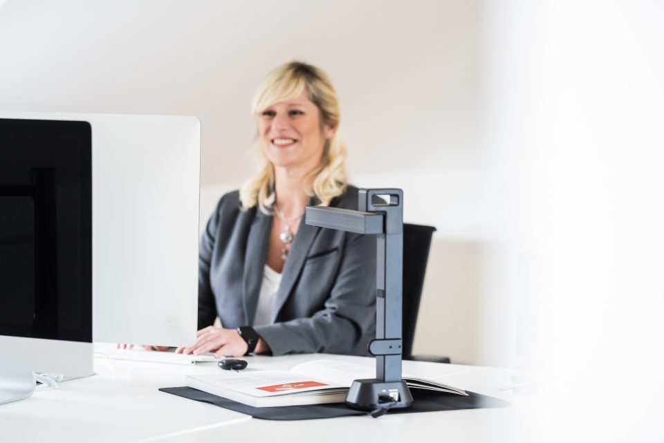 IRIScan Desk 6 Pro in use on desk being used by a blonde woman in grey business suit