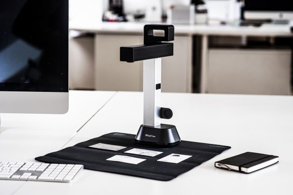 IRIScan Desk 6 set up on a white desk, scanning business cards