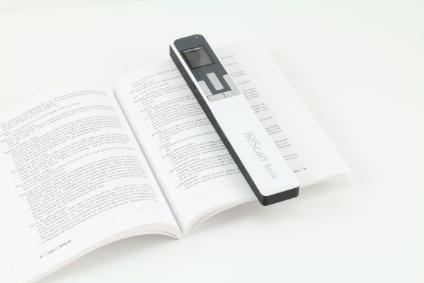 IRISScan Book 5 device in use scanning a page of text in a magazine