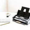 IRIScan Pro 5 on a white desk with keyboard, pencil and coffee cup