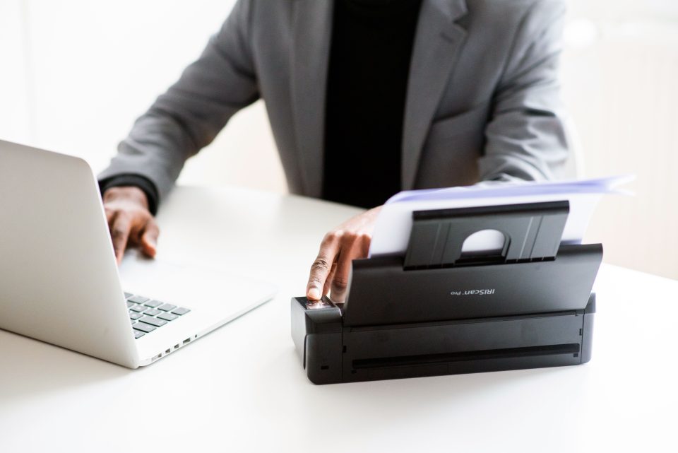 IRIScan Pro 5 in use. closeup of man in grey suit and black undershirt