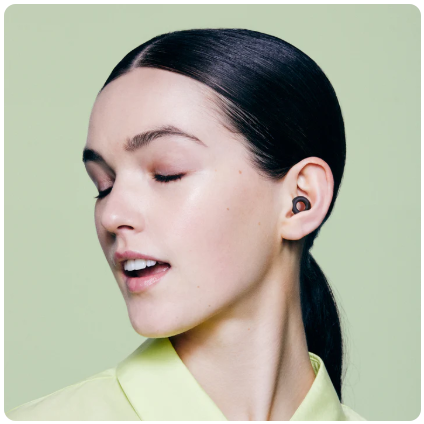 loop quiet 2 earplugs black in use by a woman in a lime green bluse with her eyes closed