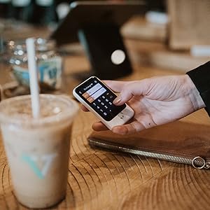 Pocketalk device in use as a currency convertor in a coffee shop