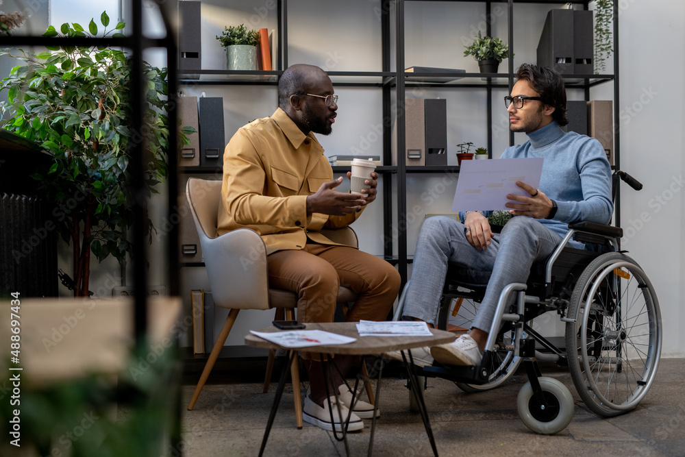 DEI illustrated through an inclusive workplace discussion between two colleagues, including a wheelchair user, highlighting equitable collaboration, accessibility, and respectful communication.