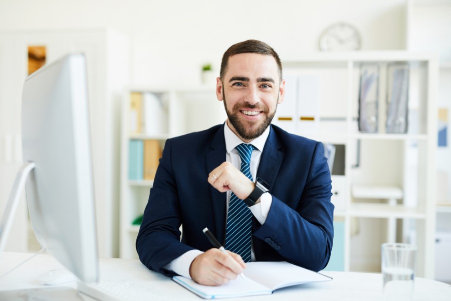 Business professional demonstrating correct desk posture while working at a computer.