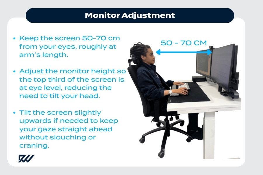 Person adjusting computer monitor to eye level at an ergonomic desk setup.