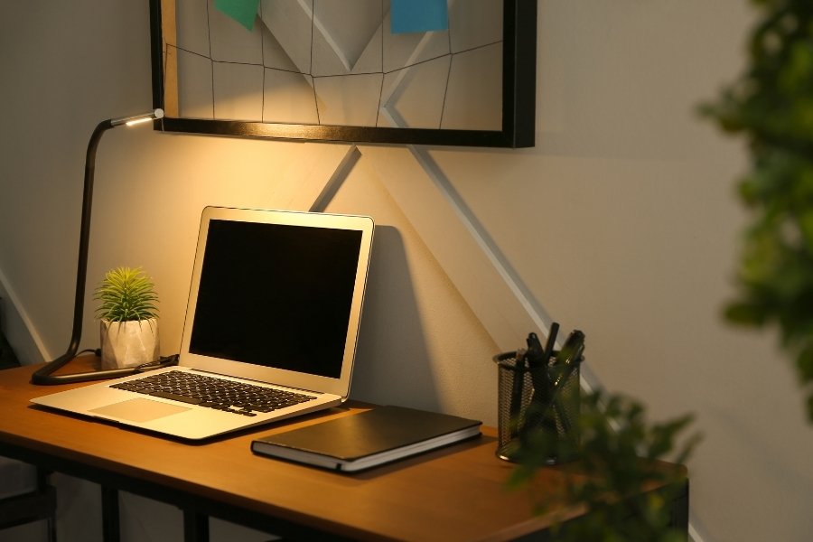Laptop desk with office task lighting from a slim LED lamp.
