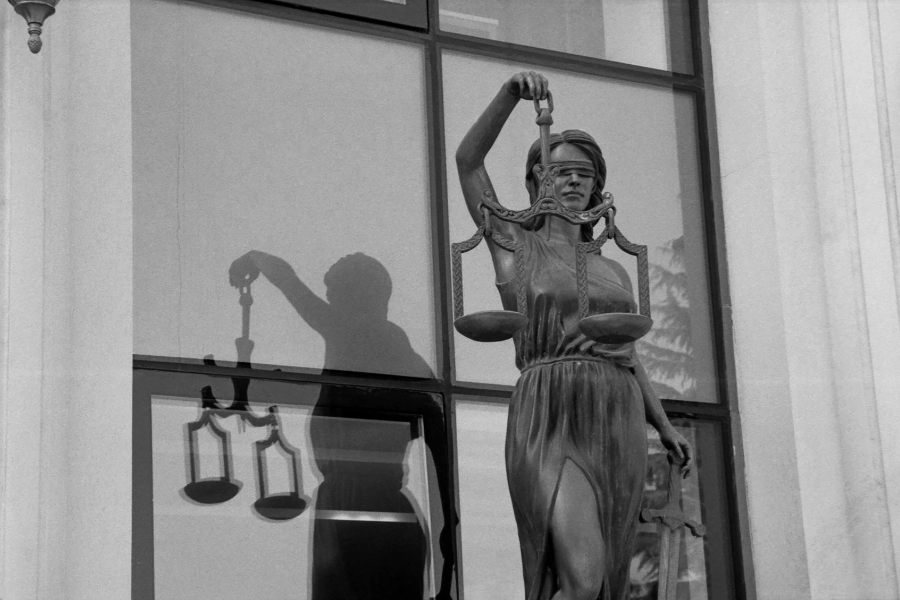 Statue of Lady Justice holding scales outside a courthouse, symbolising legal responsibility and compliance.