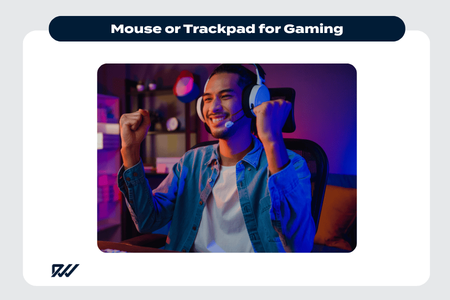 Photograph of a gamer wearing a headset, smiling and raising their fists in celebration while playing a video game at a desk.
