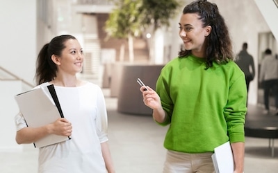Roger On 3 wireless microphone being used during a conversation between two people, showing the assistive listening device supporting clear communication in a workplace or educational setting.
