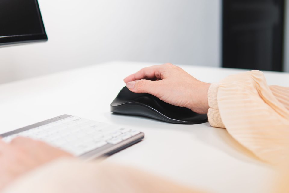 Handshoe Mouse Cordless ergonomic mouse in use beside keyboard on desk supporting natural wrist posture