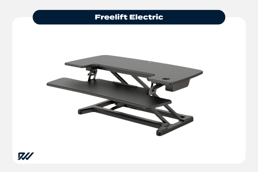 Freelift electric standing desk converter with wide surface and keyboard tray in raised position